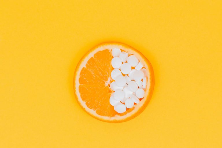 Naranja y pastillas de vitaminas para el pelo