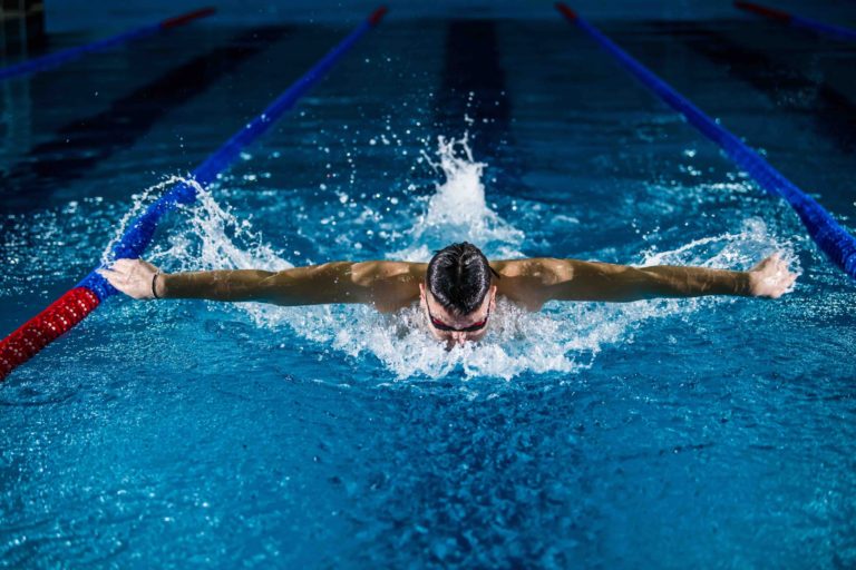 Hombre practicando natación en una piscina olímpica