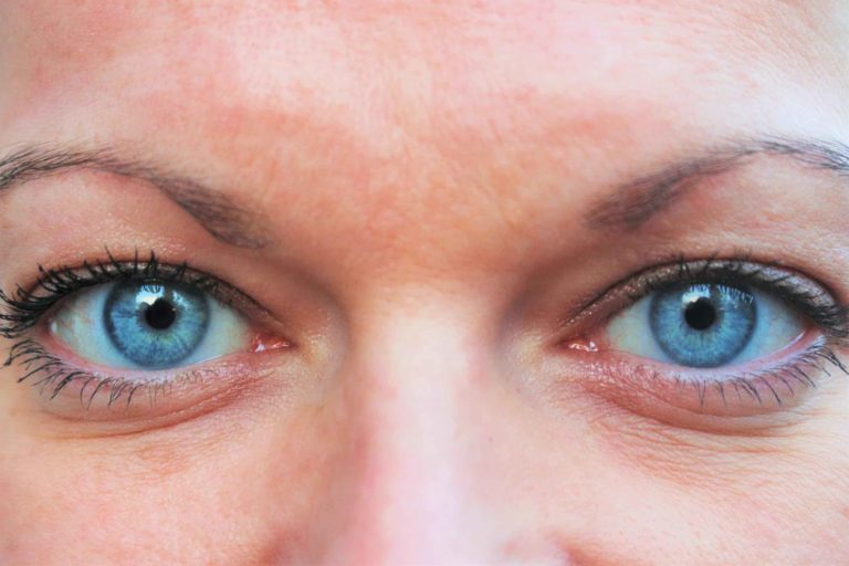 Ojos azules de una mujer con cejas finas