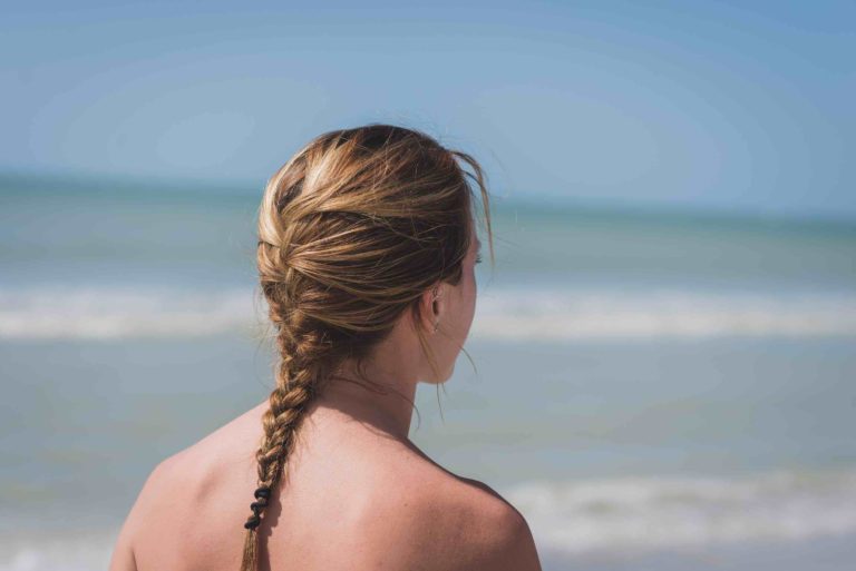 Mujer con una trenza mirando al mar